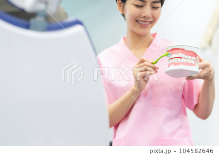 患者の治療をする歯科衛生士 104582646