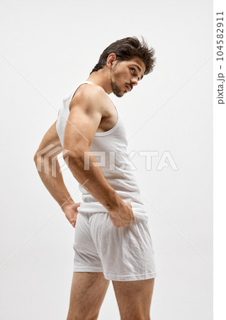 Young handsome Caucasian man wearing homewear posing over white studio background. Concept of men's health, beauty of male body, fashion, ad Young handsome Caucasian man wearing homewear posing over white studio background. Concept of men's health, beauty of male body, fashion, ad 104582911