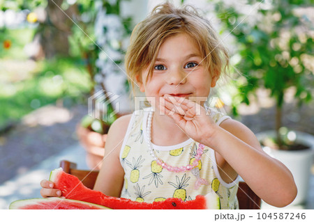 Little Girl, Preschooler, Delights in a Juicy Watermelon on a Sunny Summer Day. Child sharing a Healthy Snack with Her Family, She Embraces the Joy of Summertime Bliss Little Girl, Preschooler, Delights in a Juicy Watermelon on a Sunny Summer Day. Child sharing a Healthy Snack with Her Family, She Embraces the Joy of Summertime Bliss 104587246