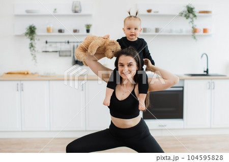 Family woman having fun with kid around neck holding toy 104595828