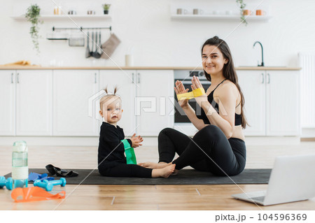 Baby learning exercises with stretch band from mom at home 104596369