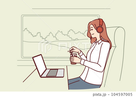 Woman train passenger uses laptop working on trip and drinks coffee sitting near large window Woman train passenger uses laptop working on trip and drinks coffee sitting near large window 104597005