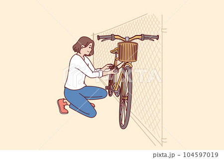 Woman parks bicycle near fence after returning from work on environmentally friendly transport 104597019