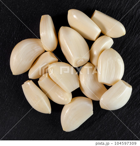 Garlic cloves. Raw garlic isolated on black background. Vegetable 104597309