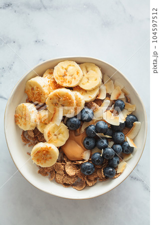 Wholegrain breakfast cereal with banana, coconut and blueberries. Vegan breakfast concept. 104597512