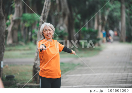 white-haired elderly person exercising in the park early in the morning. white-haired elderly person exercising in the park early in the morning. 104602099
