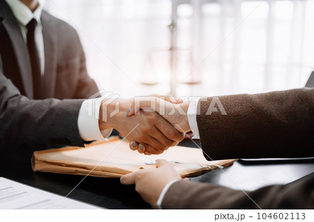 Lawyer shaking hands with client after discussing final contract agreement. Lawyer shaking hands with client after discussing final contract agreement. 104602113