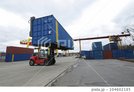 Electric forklift loader carrying cargo container in a container yard, railway station facilities. Kyiv, Ukraine 104602185