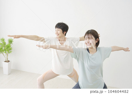 自宅でヨガをする娘と母親 英雄のポーズ 自宅でヨガをする娘と母親 英雄のポーズ 104604482