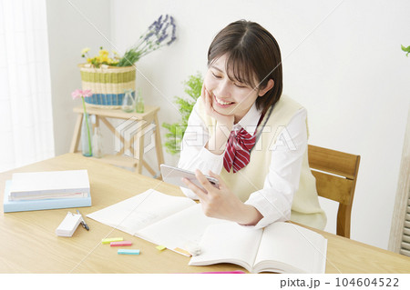 勉強中にスマホを見て息抜きする女子高生 104604522