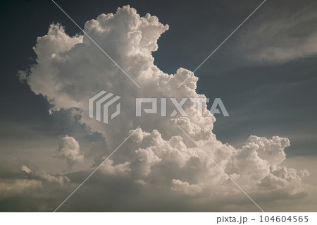 Interesting white cumulus clouds pattern against the indigo blue sky background. 104604565