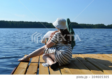 A young woman is resting on the pier. A young woman is resting on the pier. 104605305