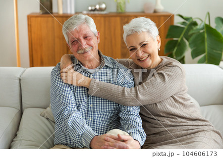 Senior adult mature couple hugging at home. Mid age old husband and wife embracing with tenderness love enjoying sweet bonding wellbeing. Grandmother grandfather together. Family moment love and care Senior adult mature couple hugging at home. Mid age old husband and wife embracing with tenderness love enjoying sweet bonding wellbeing. Grandmother grandfather together. Family moment love and care 104606173