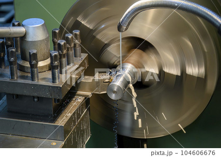 The lathe machine finish cut  metal shaft parts with liquid coolant method. 104606676
