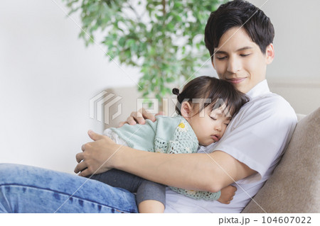 子供を抱っこして寝かしつける父親 104607022
