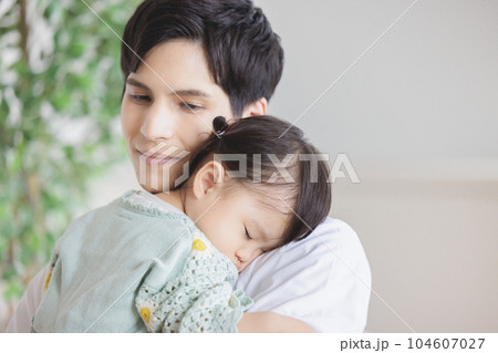 子供を抱っこして寝かしつける父親 子供を抱っこして寝かしつける父親 104607027