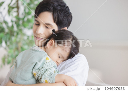 子供を抱っこして寝かしつける父親 子供を抱っこして寝かしつける父親 104607028