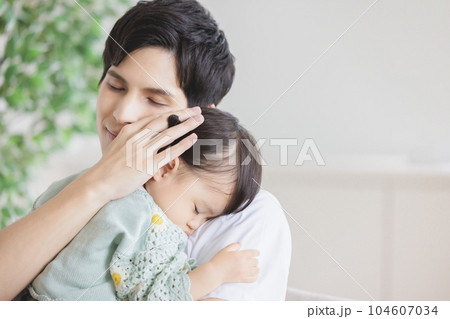 子供を抱っこして寝かしつける父親 子供を抱っこして寝かしつける父親 104607034