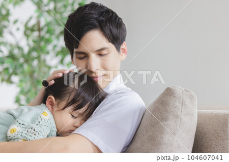 子供を抱っこして寝かしつける父親 104607041
