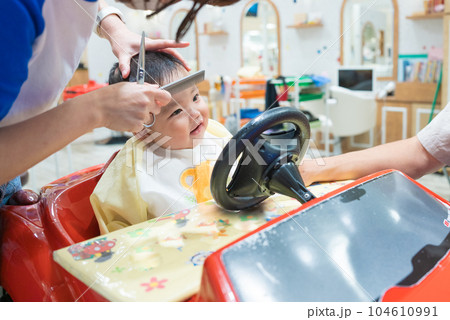 初めての美容室で髪を切ってもらう生後8か月の男の子の赤ちゃん 104610991