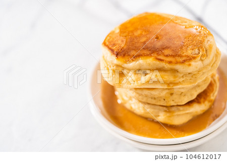 Stack of eggnog pancakes with drizzled eggnog caramel sauce on top. 104612017