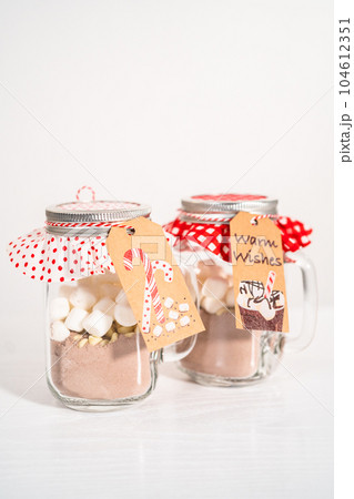 Making homemade hot chocolate mix in drinking mason jar for Christmas food gift. Making homemade hot chocolate mix in drinking mason jar for Christmas food gift. 104612351