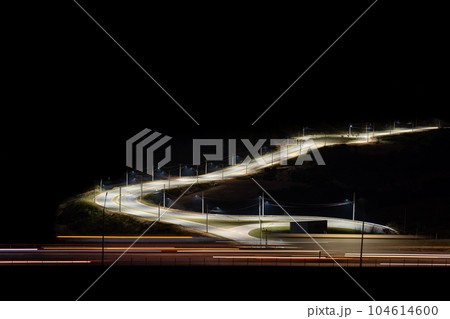 Long Exposure of Empty Highway at Night with Light Trails and Illuminated Road Diversion 104614600