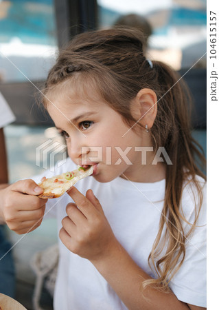Little girl eating pizza in cafe. Cute girl have lunch after walking in park 104615157