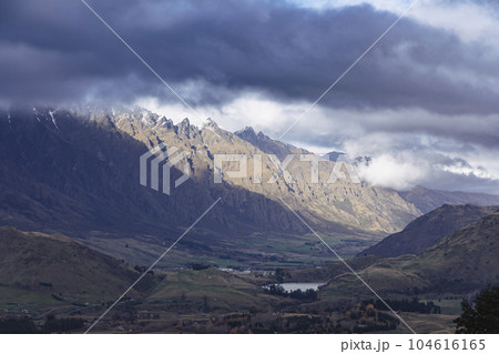 Photograph of a mountain range and large valley in Queenstown on the South Island of New Zealand Photograph of a mountain range and large valley in Queenstown on the South Island of New Zealand 104616165