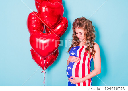young woman dressed in patriotic clothing wearing a US flag 104616798