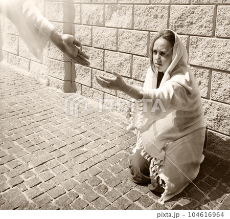 A girl in poor clothes sits on the ground A girl in poor clothes sits on the ground 104616964