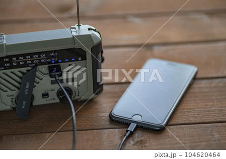 防災ラジオからスマホに充電中 104620464