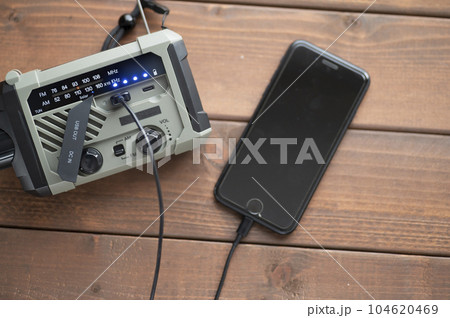 防災ラジオからスマホに充電中 104620469
