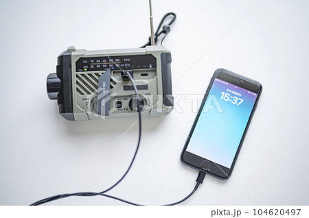防災ラジオからスマホに充電中 104620497