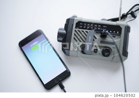 防災ラジオからスマホに充電中 104620502