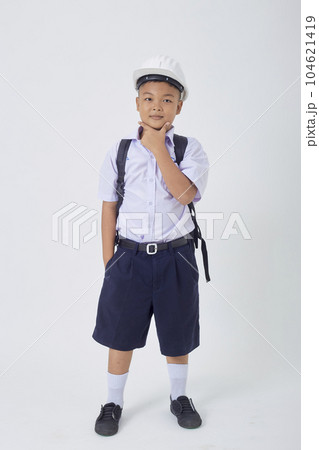 A young Asian cute boy standing in a Thai school uniform with a backpack bag and safety helmet on a white background banner A young Asian cute boy standing in a Thai school uniform with a backpack bag and safety helmet on a white background banner 104621419