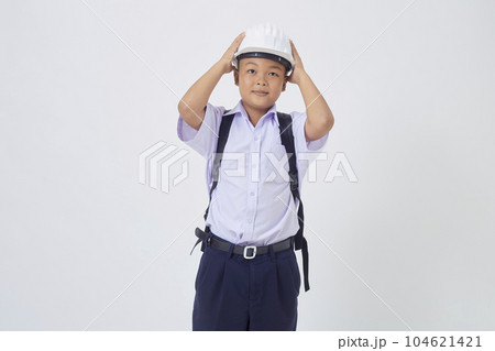 A young Asian cute boy standing in a Thai school uniform with a backpack bag and safety helmet on a white background banner A young Asian cute boy standing in a Thai school uniform with a backpack bag and safety helmet on a white background banner 104621421