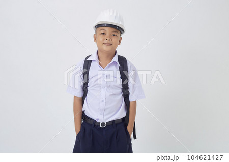 A young Asian cute boy standing in a Thai school uniform with a backpack bag and safety helmet on a white background banner A young Asian cute boy standing in a Thai school uniform with a backpack bag and safety helmet on a white background banner 104621427