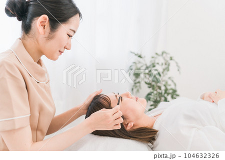 まつげエクステを施術するアイリスト 104632326