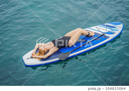 Young women Having Fun Stand Up Paddling in blue water seaamong the rocks in Montenegro. SUP Young women Having Fun Stand Up Paddling in blue water seaamong the rocks in Montenegro. SUP 104633064