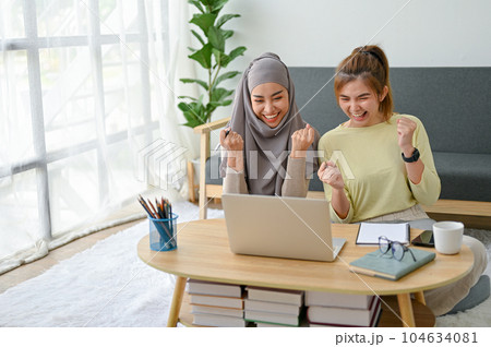 Cheerful muslim woman celebrating with her friend after receiving good news. Cheerful muslim woman celebrating with her friend after receiving good news. 104634081