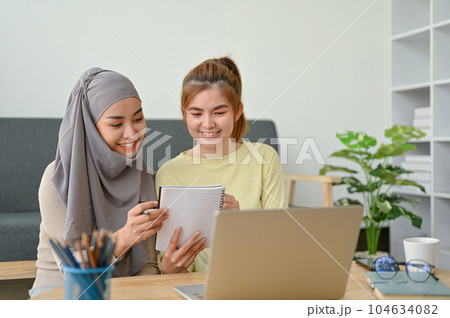 Young student study together in their time, muslim woman reading with her friend. Young student study together in their time, muslim woman reading with her friend. 104634082