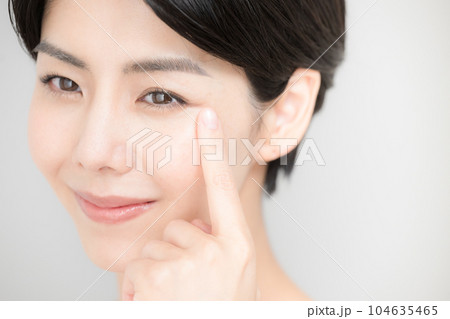 美容などに使いやすい睫毛や目元を指さす女性のアップ 104635465