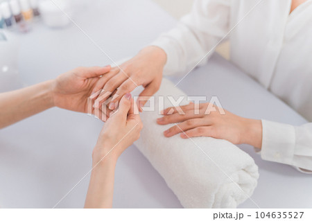 ネイルサロンで手を見てカウンセリングするネイリストと女性 104635527