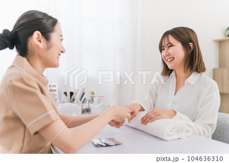 ネイルサロンでアセトンでネイルオフをするネイリストとアジア人女性 104636310