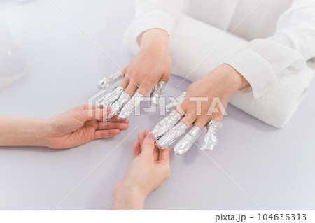 ネイルサロンでアセトンでネイルオフをするネイリストとアジア人女性 104636313