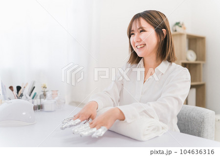 ネイルサロンでアセトンでネイルオフをするネイリストとアジア人女性 104636316