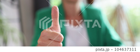 Businesswoman sitting at workplace and showing thumb up sign Businesswoman sitting at workplace and showing thumb up sign 104637311