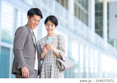 デートの時にスマホを操作する若い夫婦 104637872
