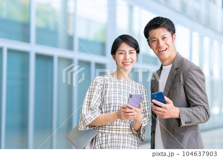 デートの時にスマホを操作する若い夫婦 104637903